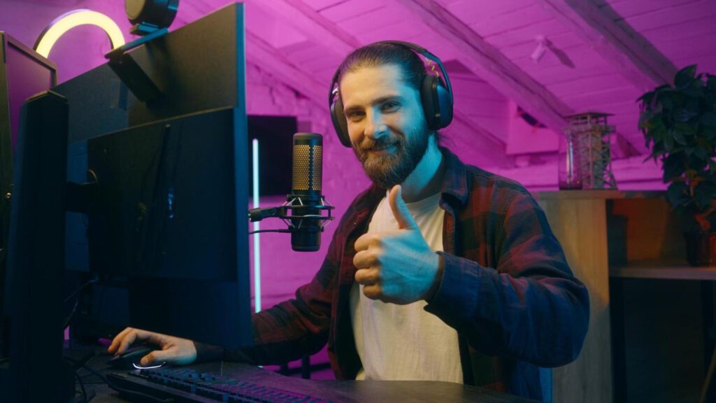 Man sitting at the computer with a microphone